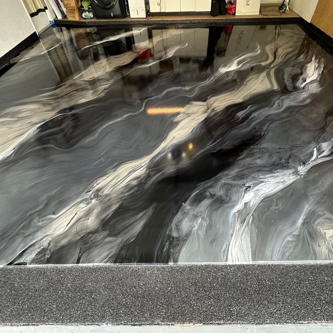 Metallic epoxy flooring with artistic lava flow design installed by epoxy flooring contractors near me in Cape Coral FL.