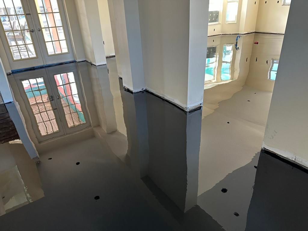 Interior shot of a room with tall windows, columns, and a gray and white color scheme.