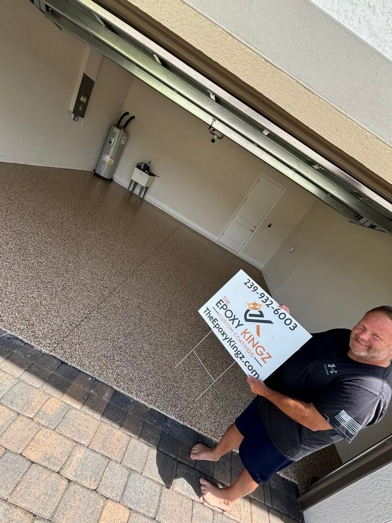 Man holding a sign in a garage with epoxy flooring.