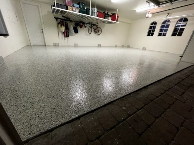 Garage with a gray speckled epoxy floor and storage racks.