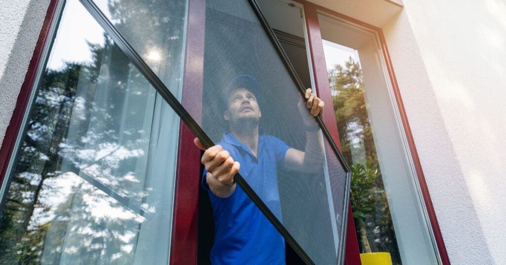 2 Window Screen BC installers removing a window so they can install the patio screen properly flush with the window.