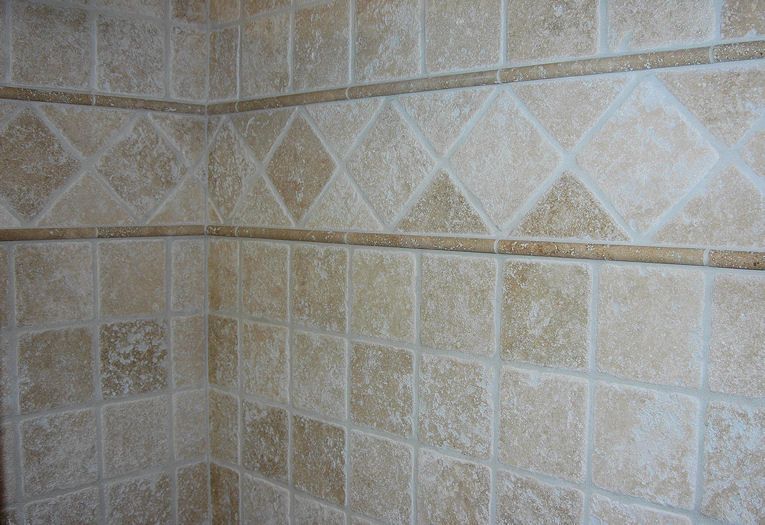 A tiled wall with a diamond pattern on it