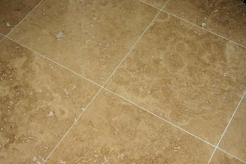 A close up of a tiled floor with a diagonal pattern.