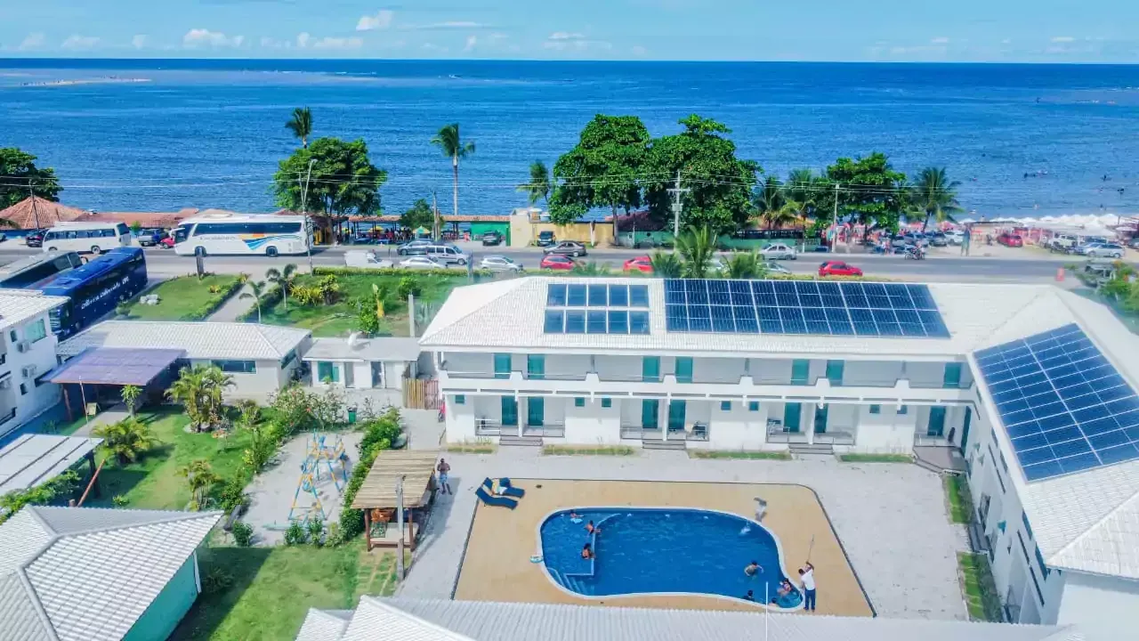 Uma vista aérea de um hotel com piscina em frente ao oceano Areia do Atlântico Hotel