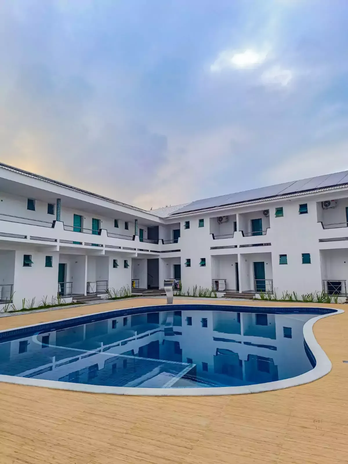 Há uma grande piscina no meio de um hotel Areia do Atlântico Hotel 