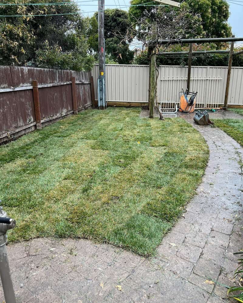 A Backyard With a Brick Walkway and a Lawn Mower — CLF Landscaping In Hawker, ACT