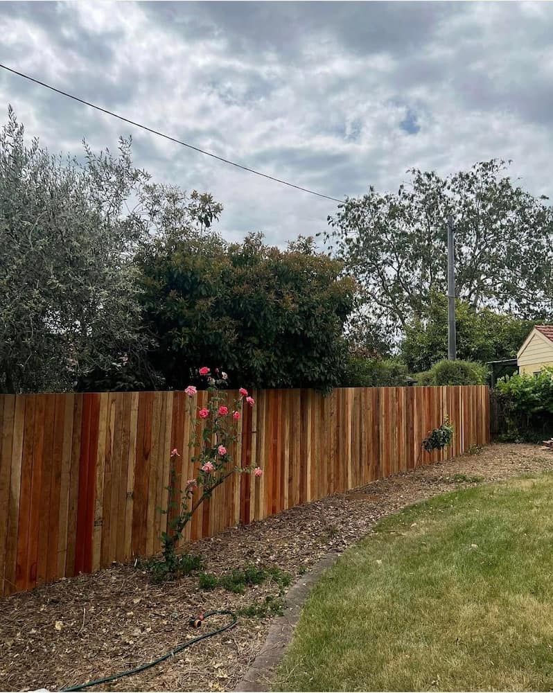 A Wooden Fence Surrounds a Lush Green Yard — CLF Landscaping In Hawker, ACT