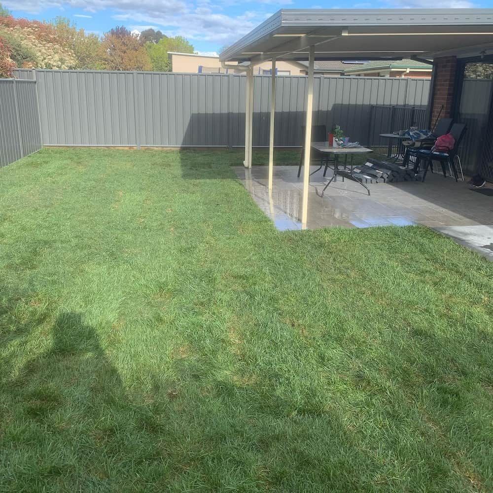 A Backyard With a Covered Patio and a Table and Chairs — CLF Landscaping In Hawker, ACT