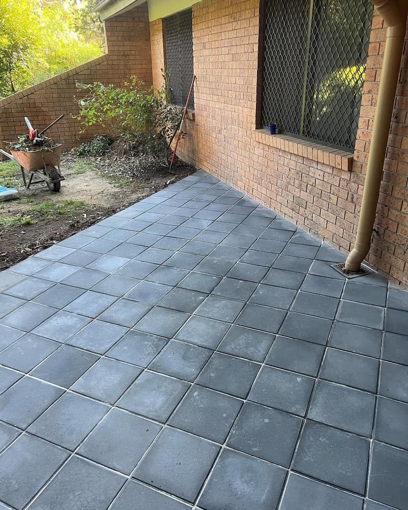 A Brick Building With a Patio and a Wheelbarrow in Front of It — CLF Landscaping In Hawker, ACT