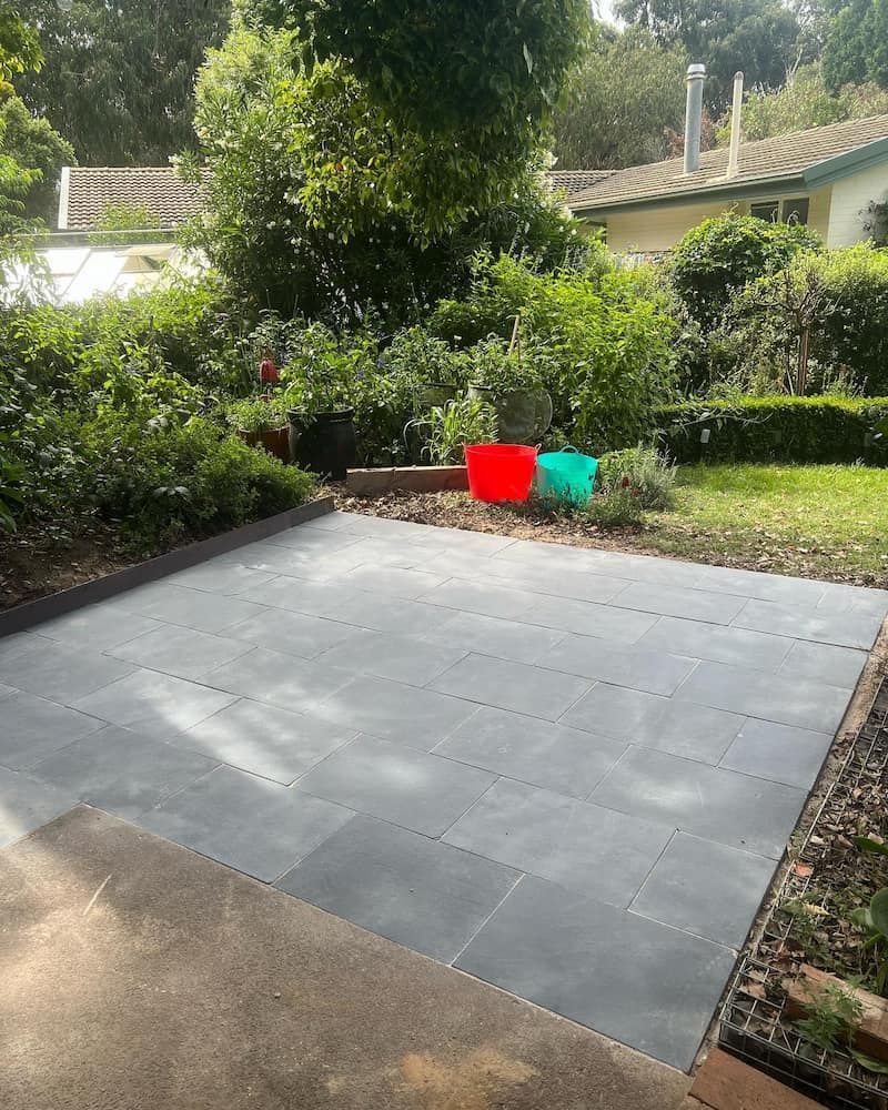A Backyard With a Patio and a House in the Background — CLF Landscaping In Hawker, ACT