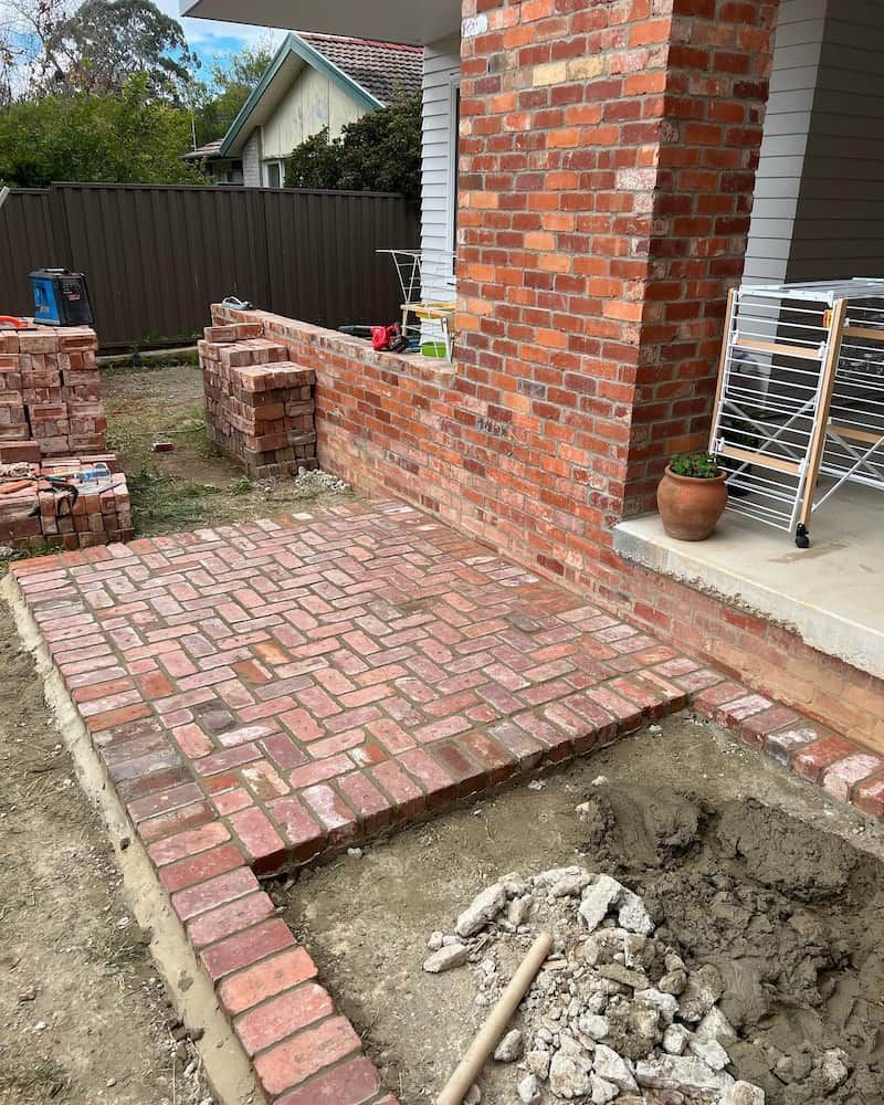 A Brick Walkway is Being Built in Front of a Brick House — CLF Landscaping In Hawker, ACT