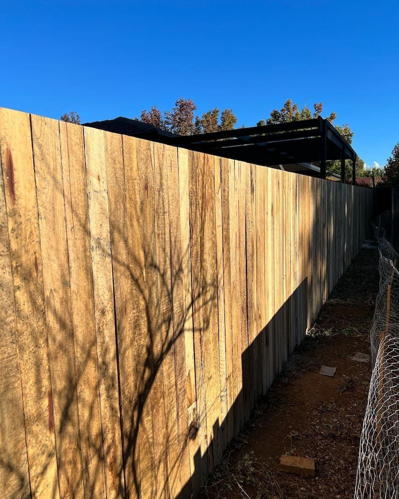 A Wooden Fence With a Blue Sky in the Background — CLF Landscaping In Hawker, ACT