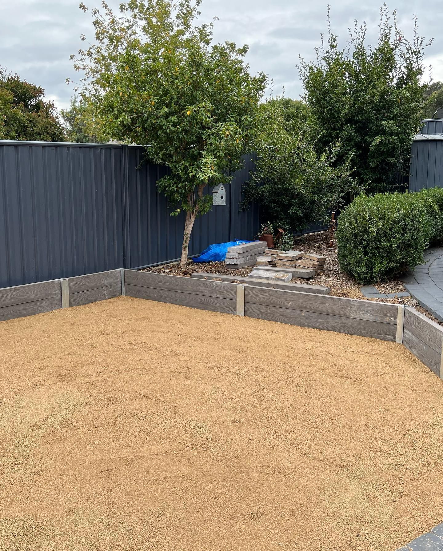 A Backyard With A Wooden Retaining Wall — CLF Landscaping In Hawker, ACT