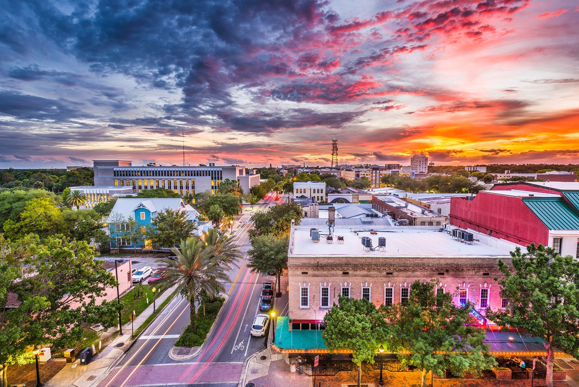 an aerial view of a city at sunset with lots of buildings and trees .