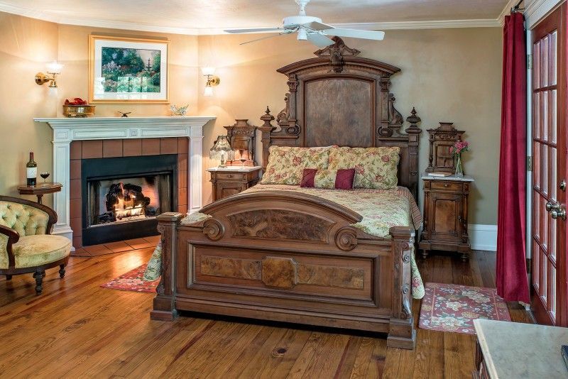 a bedroom with a bed , fireplace and chair .