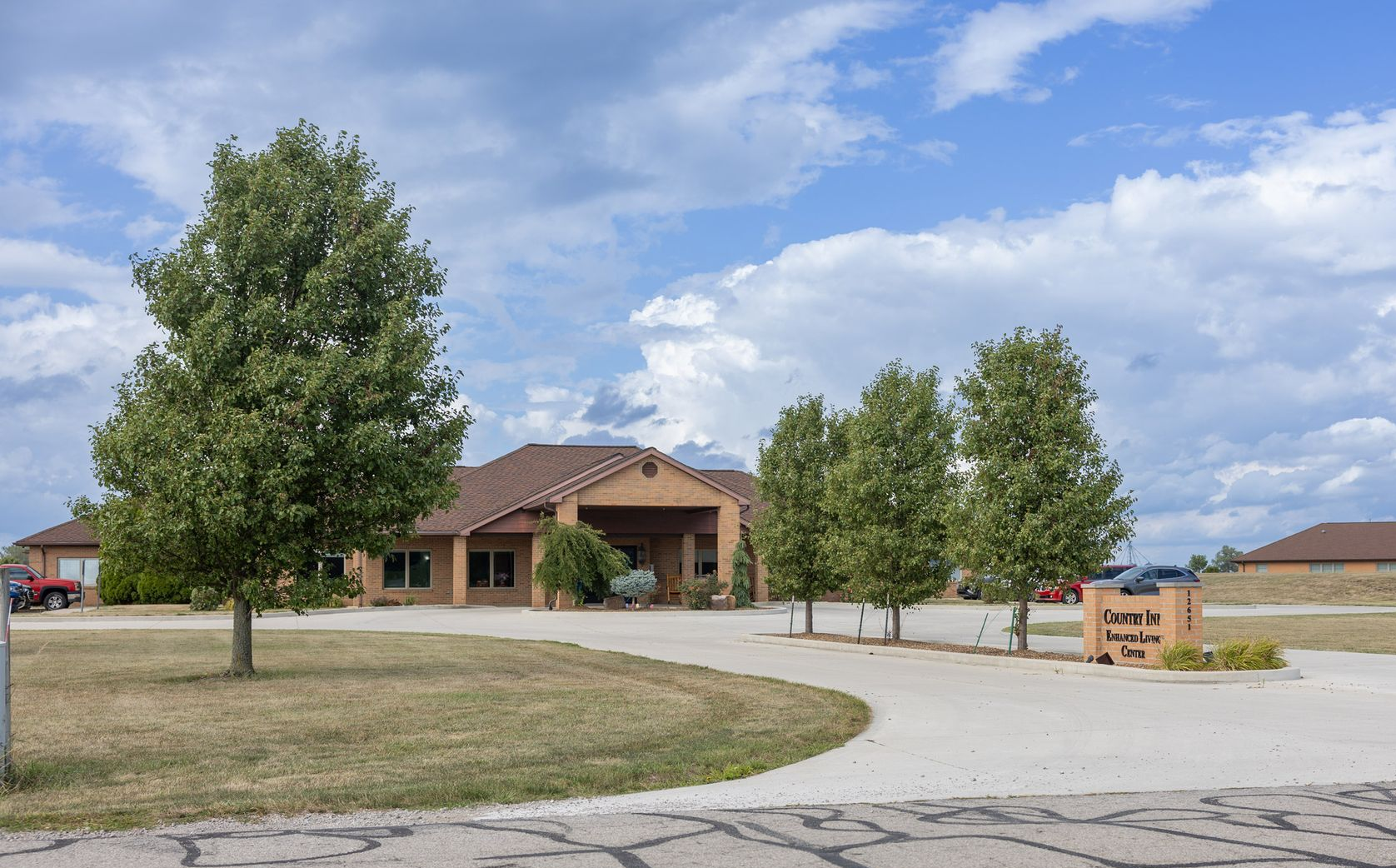 Exterior of building with trees, lawn, and sign that reads 