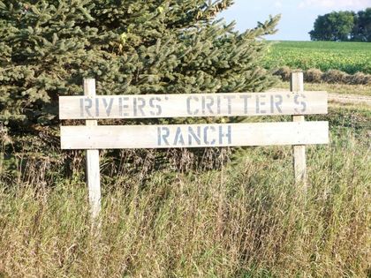 A wooden sign that says rivers critters ranch