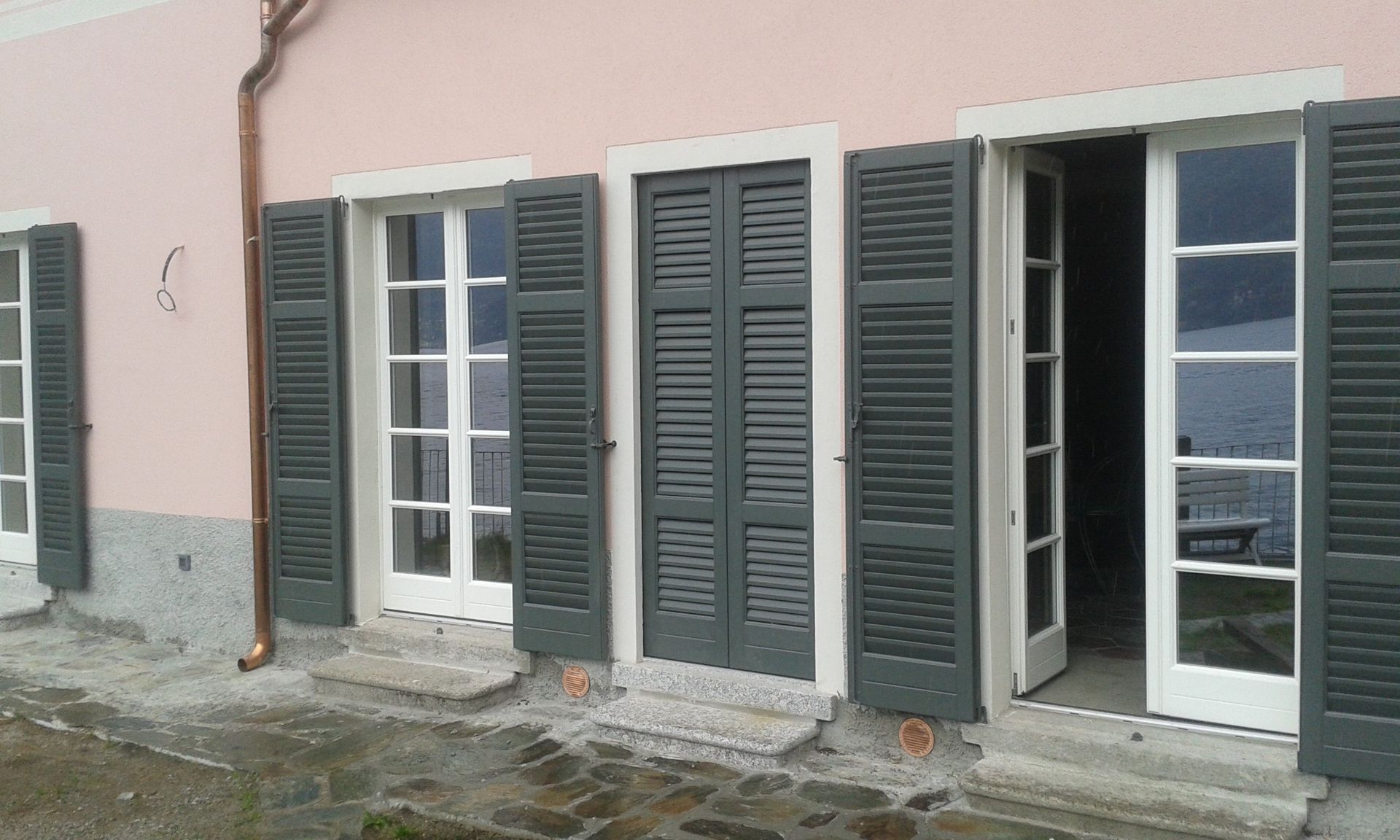 casa rosa con persiane verde scuro