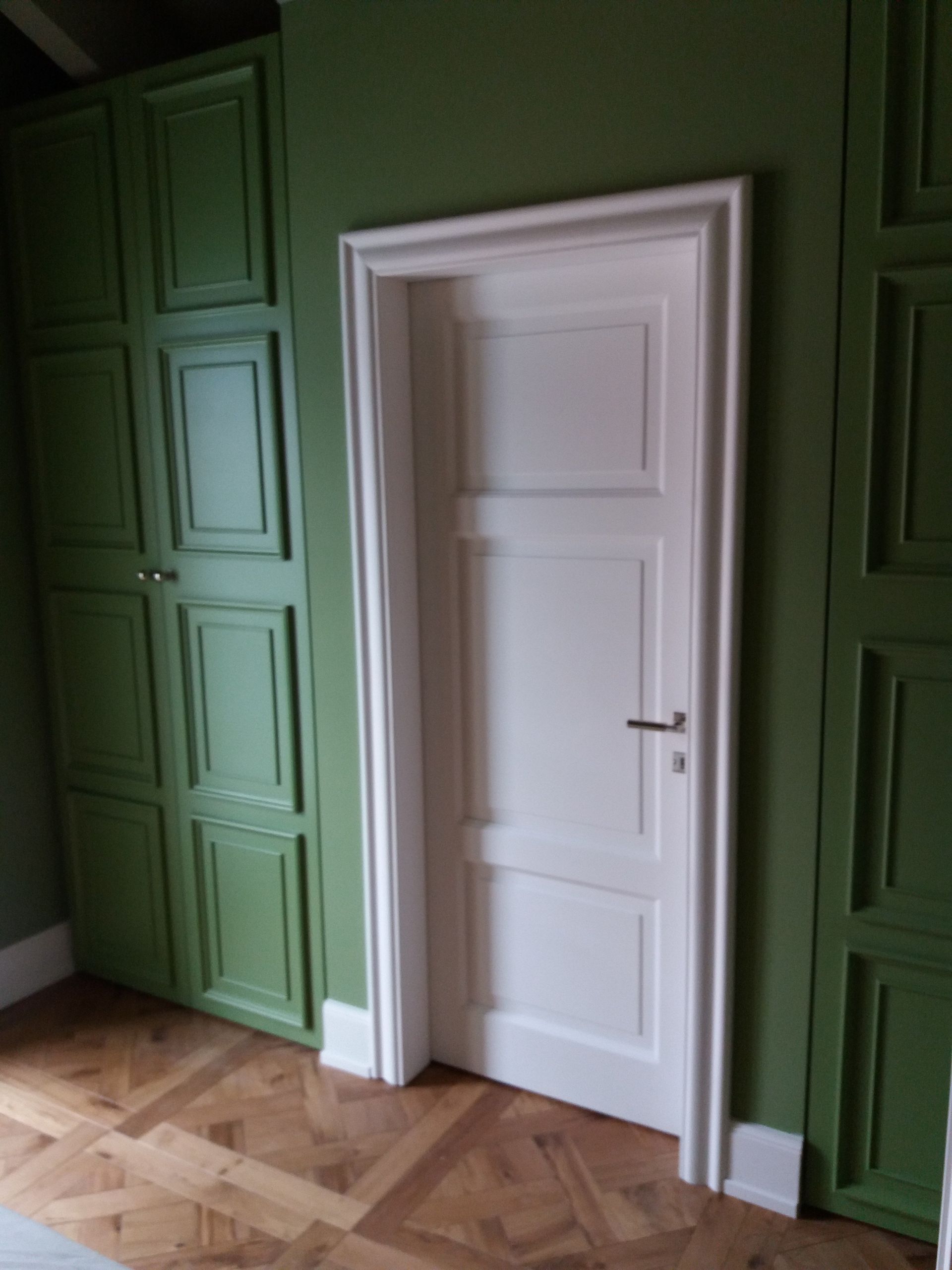 porta a battente in legno su parete verde