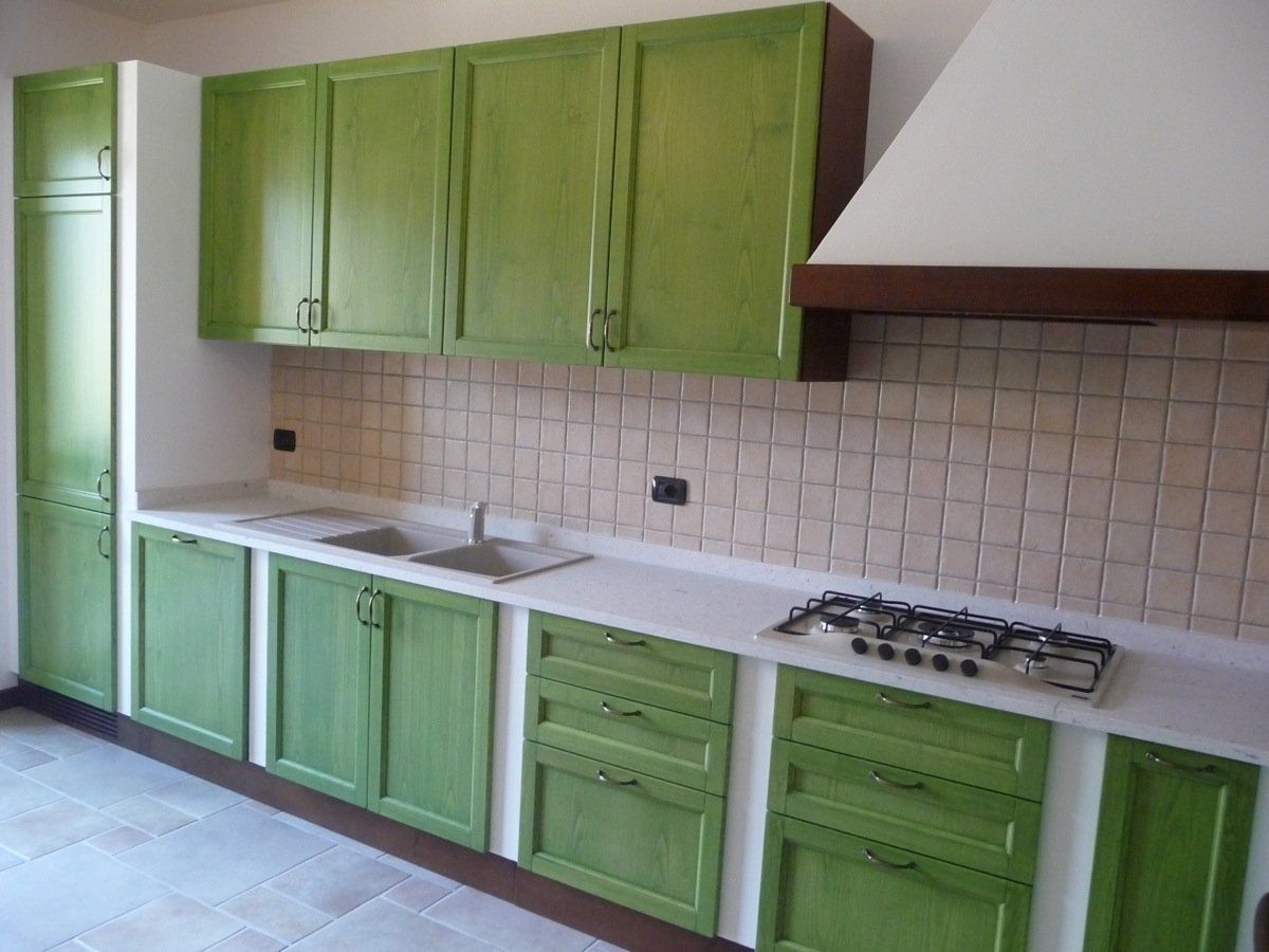 cucina su misura con cassetti in legno laccato verde e piano cottura