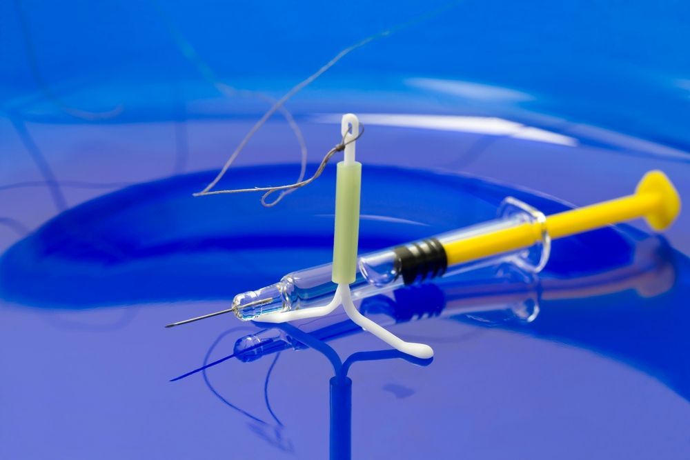 A Syringe With a Hook Attached to It is on a Blue Surface — One Stop Medical in Mackay, QLD