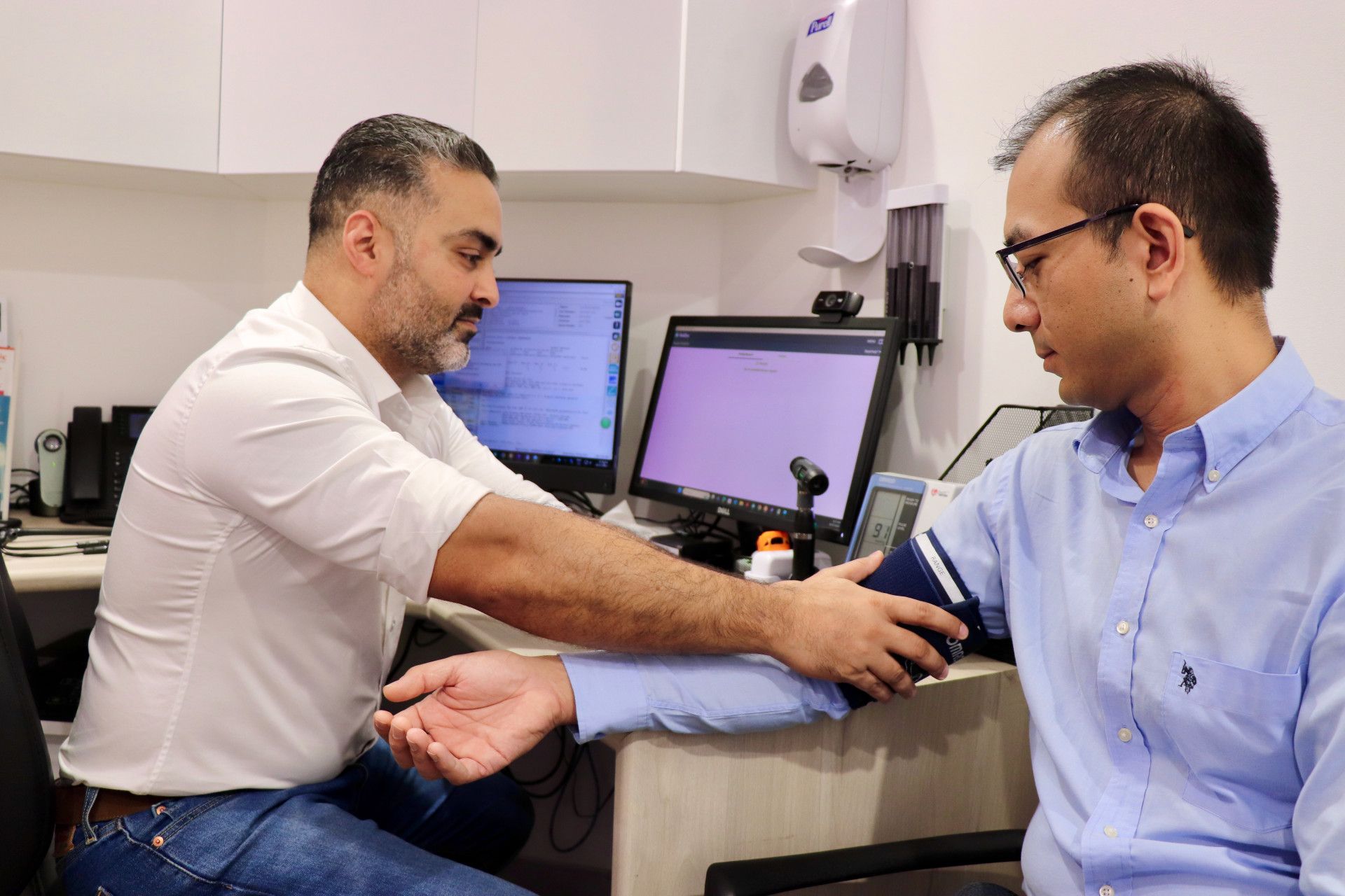 Doctor taking a patient's blood pressure in a medical office.— One Stop Medical in Mackay, QLD