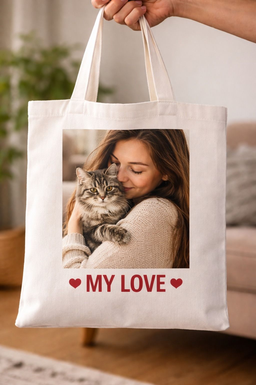 Borsa tote bianca con raffigurata una donna che tiene in braccio un gatto e la scritta 