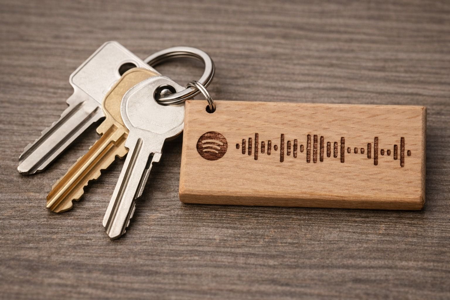 Chiavi e portachiavi in ​​legno con codice Spotify su una superficie di legno.
