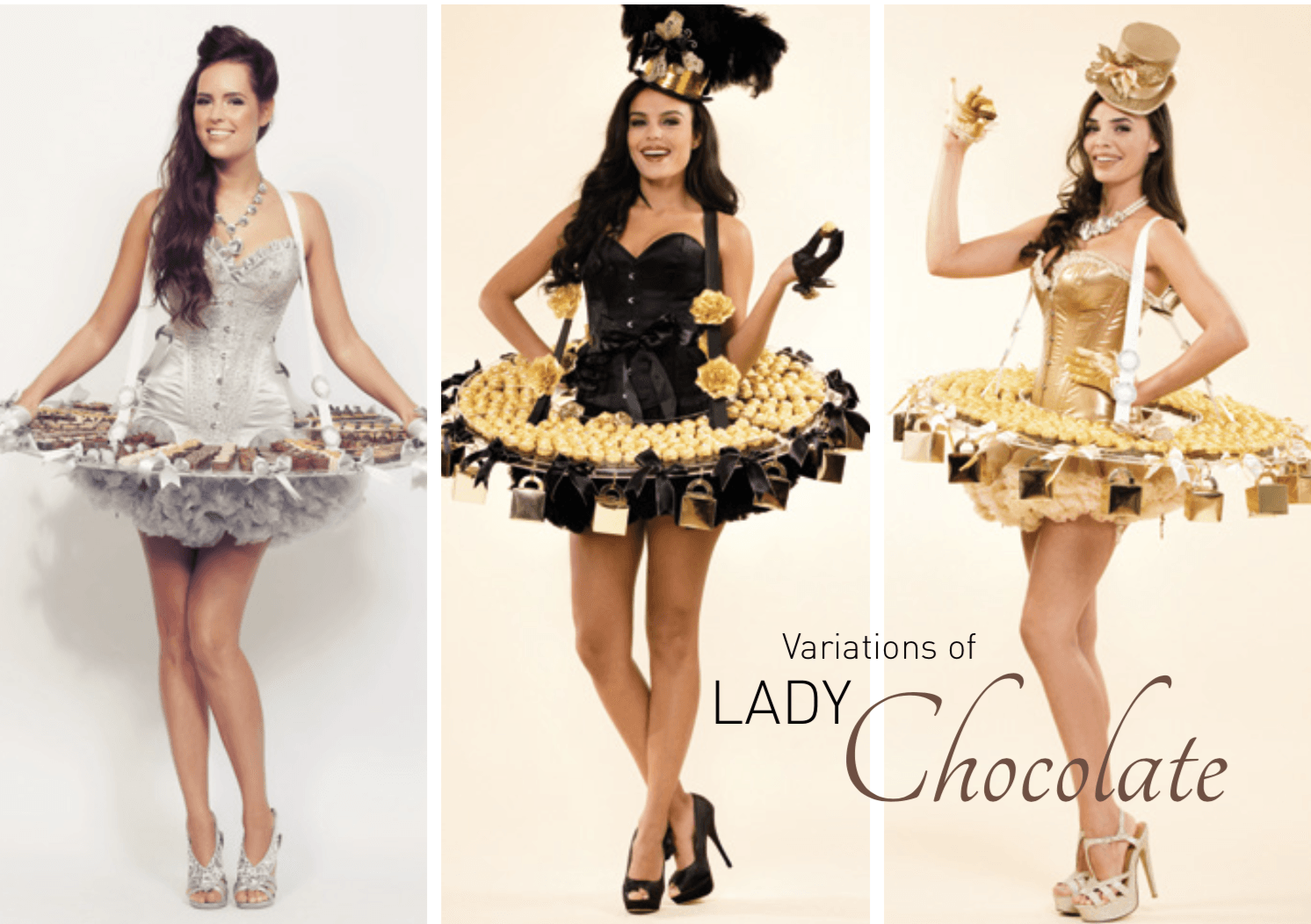 Drie vrouwen, gekleed in jurken van chocolade en met uitgebreide haarversieringen, glimlachen.