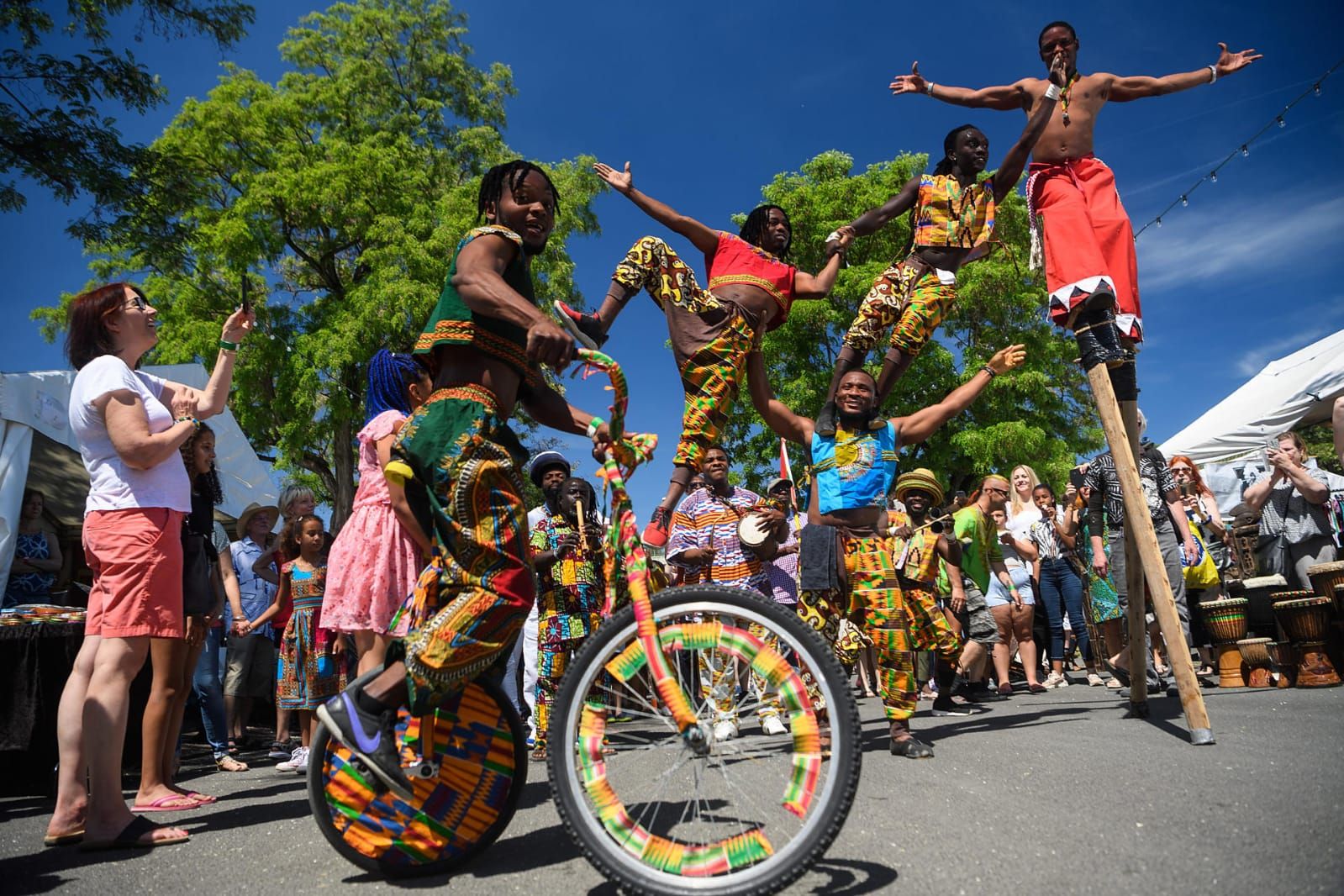 Afrikaanse artiesten op eenwielers, stelten en met evenwichtskunsten op een openluchtfestival.