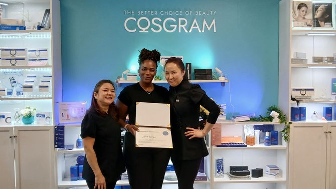 Three woman standing in front of a med spa wall featuring Cosgram products