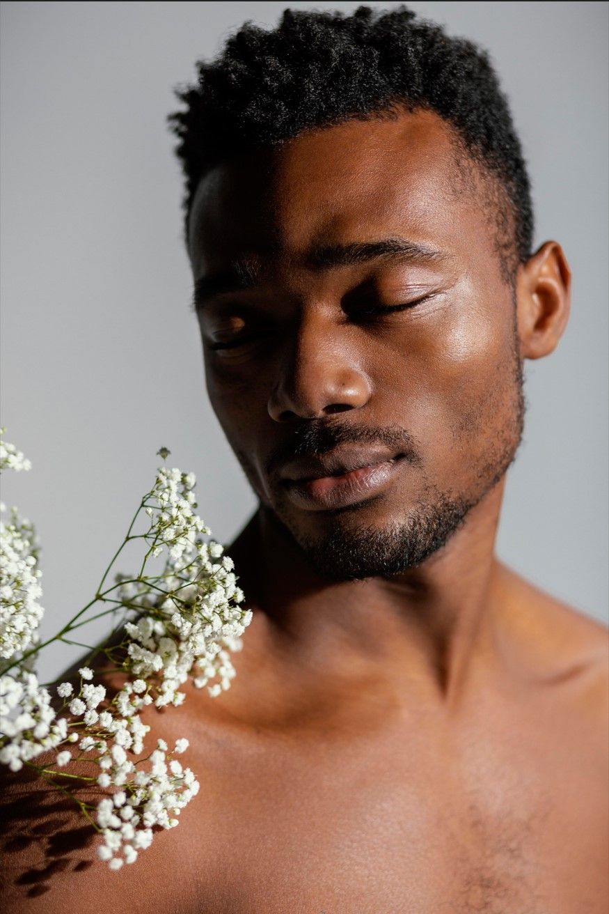 a shirtless man is shaving his face against a white background .