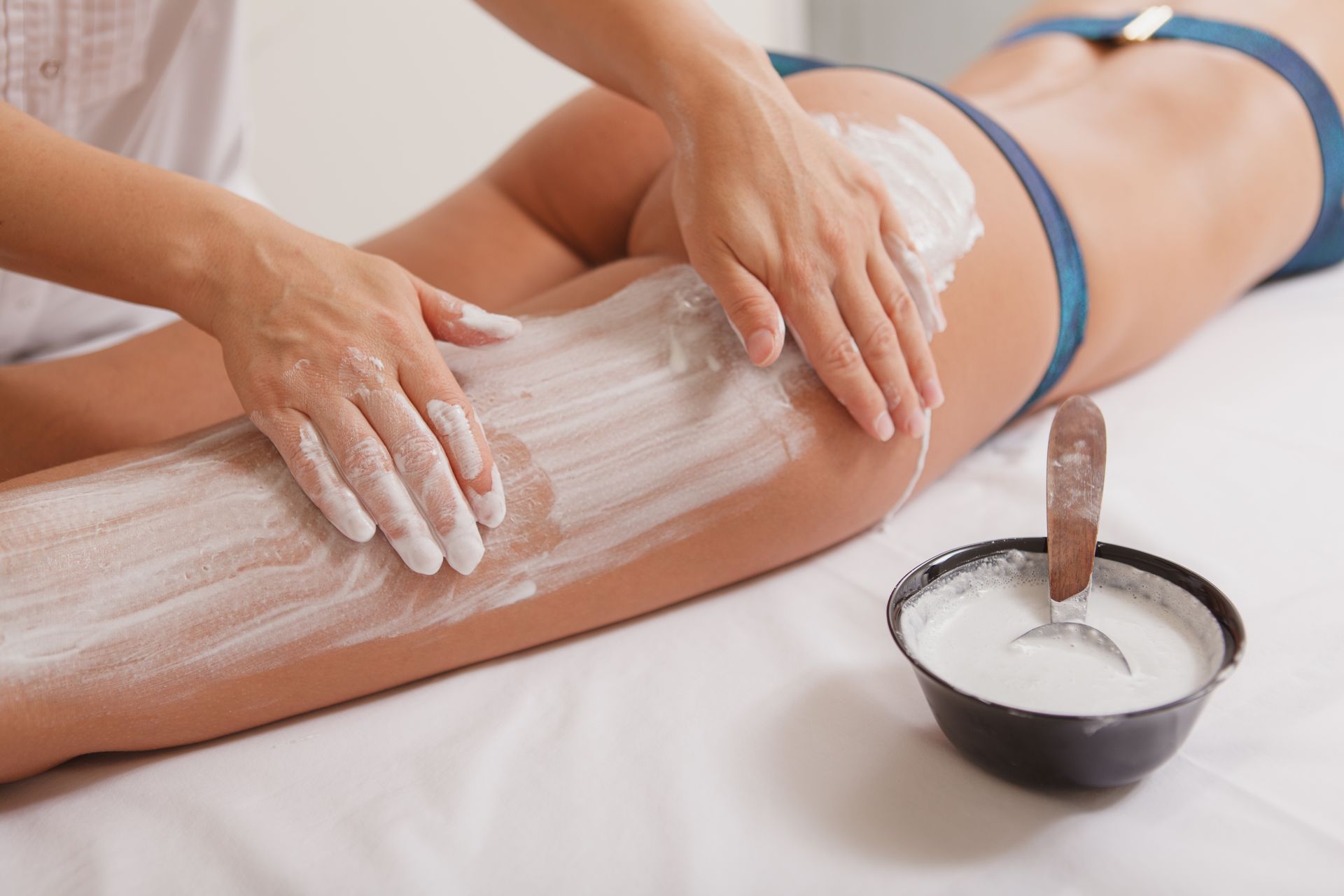 a woman in a bikini is getting a massage on her leg