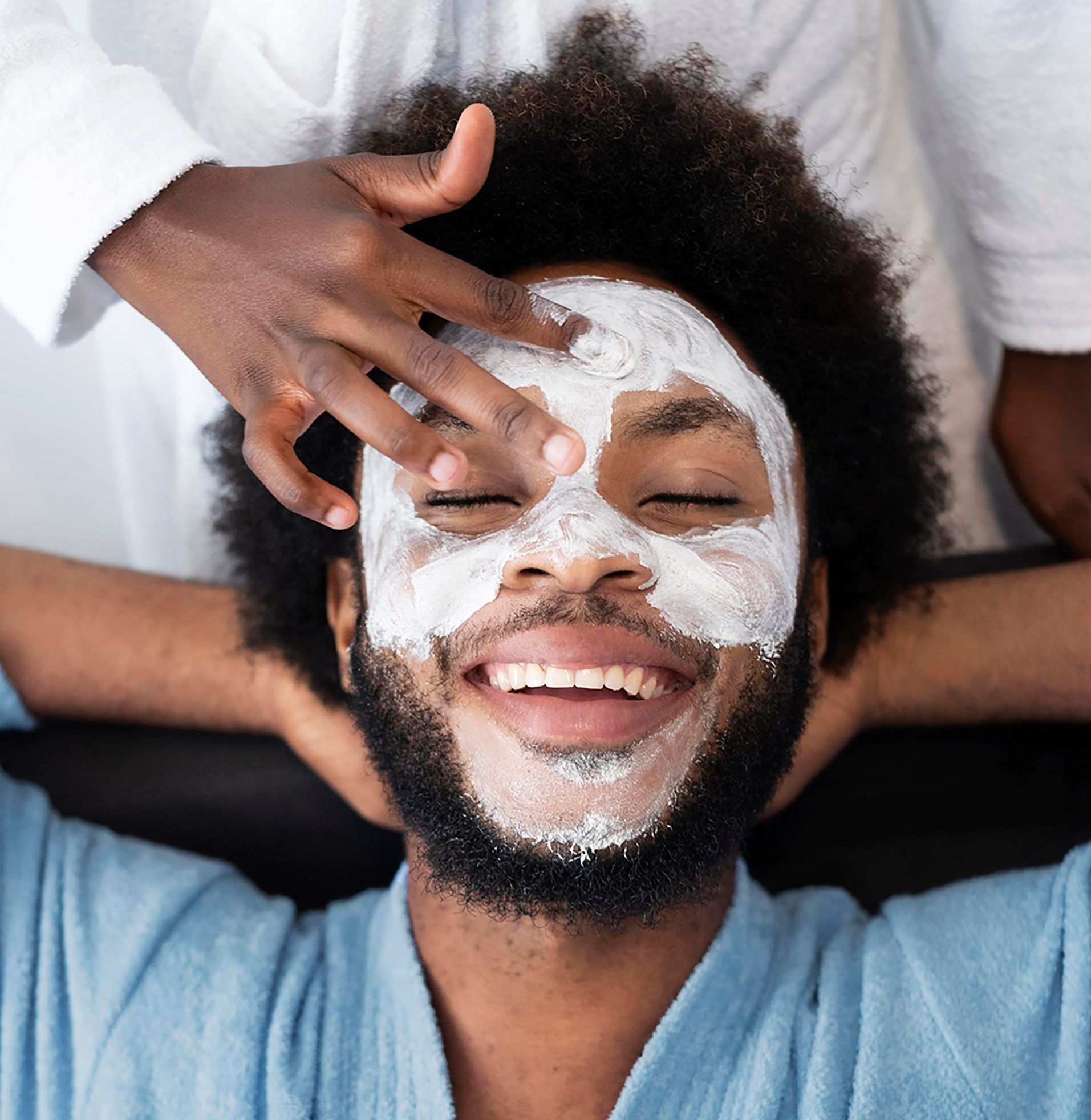 A woman is getting a facial massage at a spa.