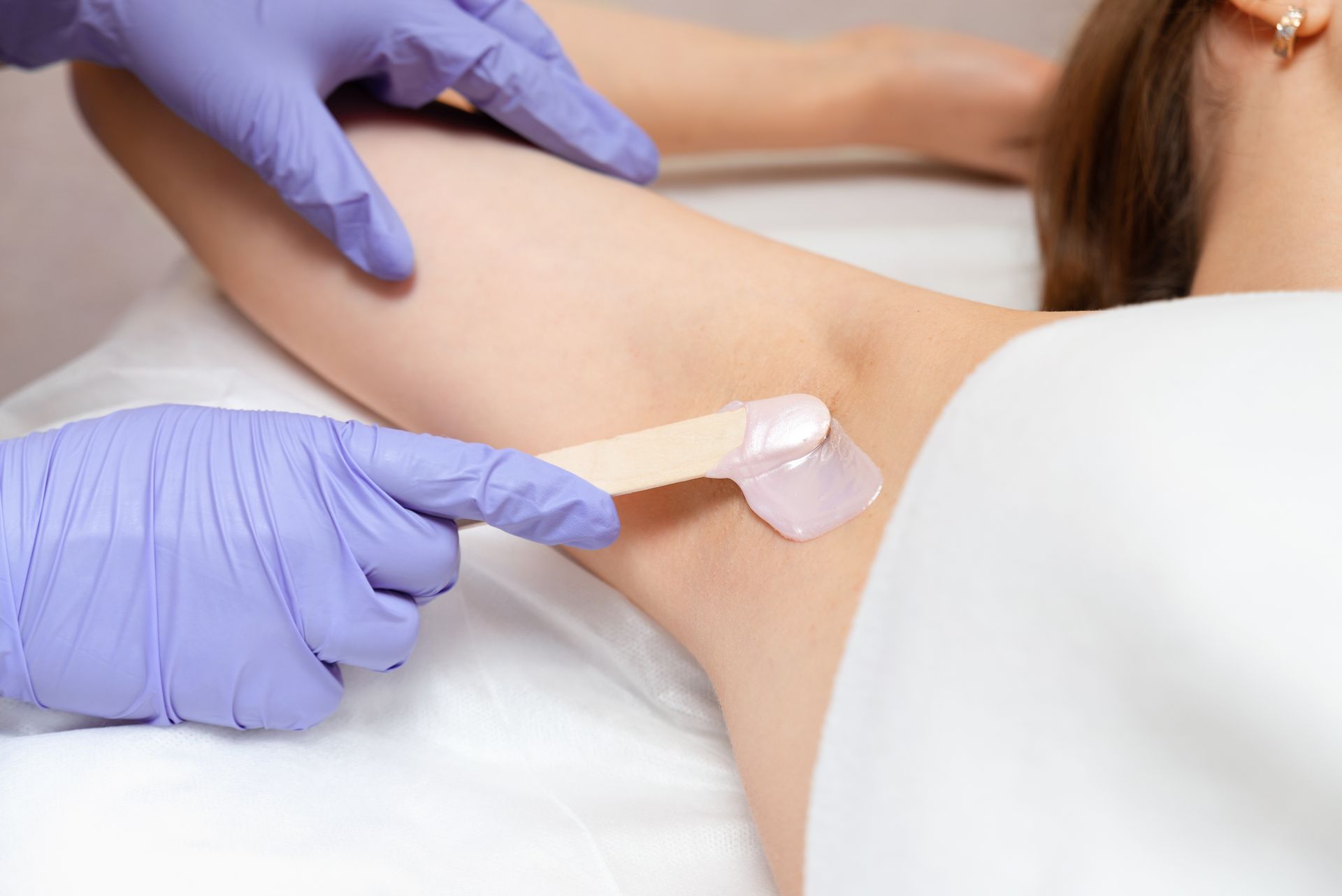 a woman is getting her armpit waxed in a beauty salon .