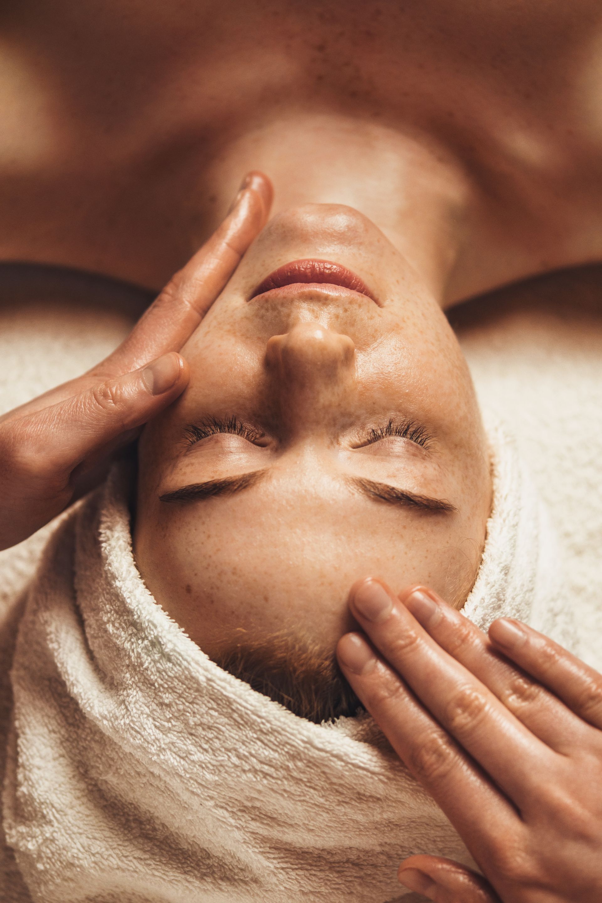 a woman is getting a facial massage at a spa .
