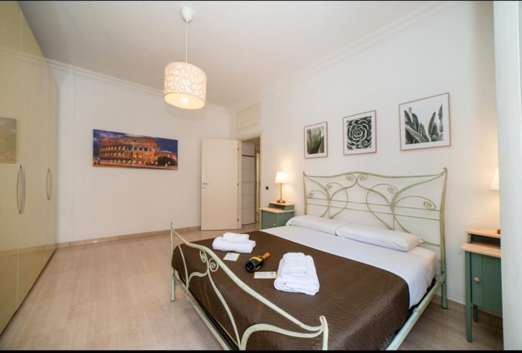 Camera da letto con letto matrimoniale, opere d'arte, comodini e armadio.