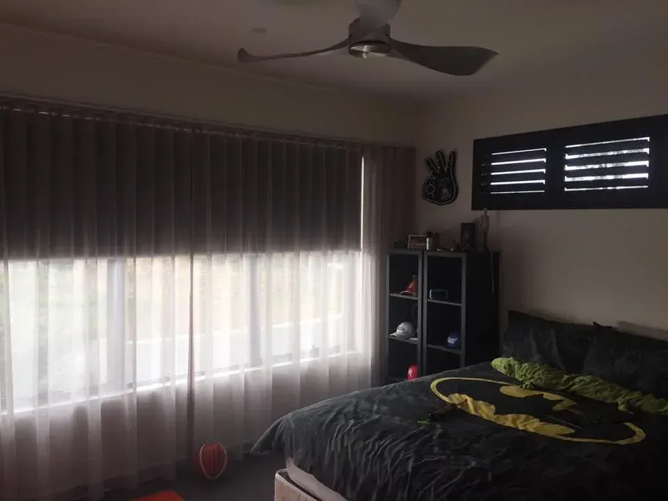A Bedroom With A Batman Comforter And A Ceiling Fan — Spring Crest Blinds, Awnings & Security Doors in Golden Square, VIC