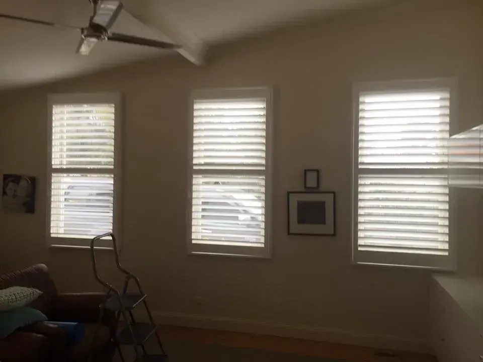 A Living Room With Three Windows And A Ceiling Fan — Spring Crest Blinds, Awnings & Security Doors in Golden Square, VIC