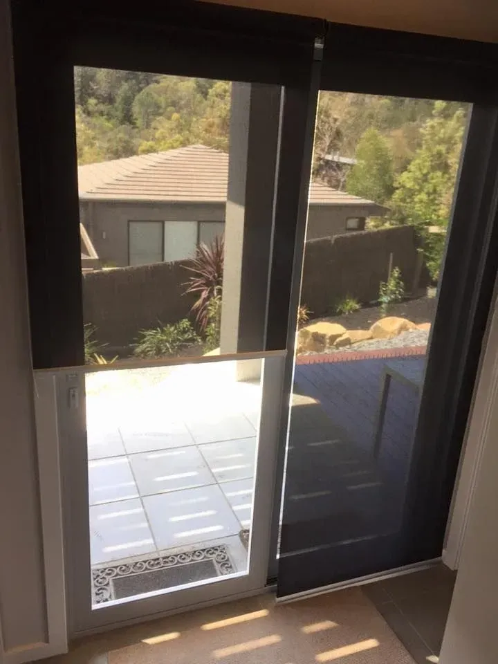 A Sliding Glass Door With Black Blinds Is Open To A Patio — Spring Crest Blinds, Awnings & Security Doors in Golden Square, VIC