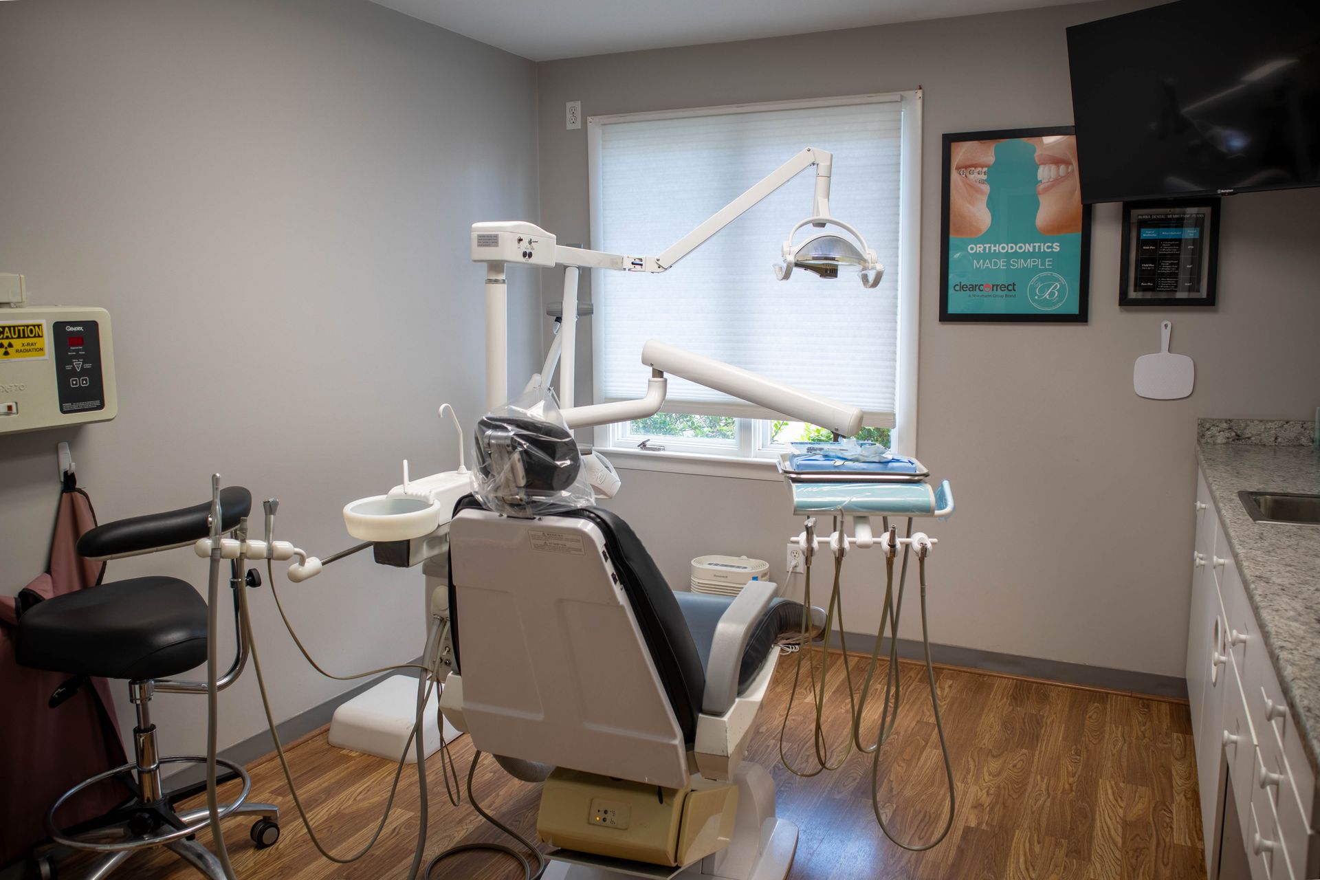 Dental office with chair, overhead light, and equipment in a clean treatment room.