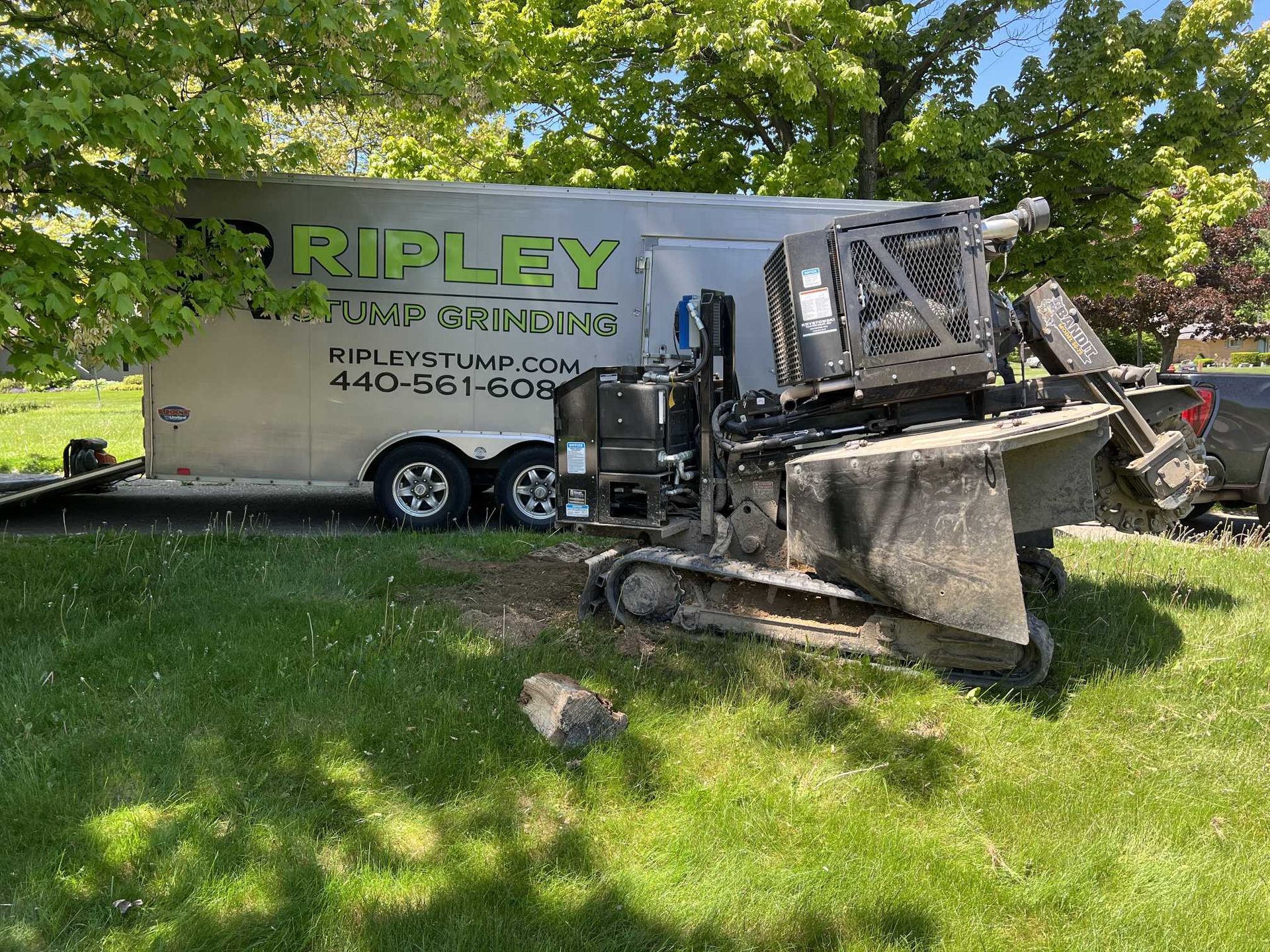 A bulldozer is parked in front of a trailer.