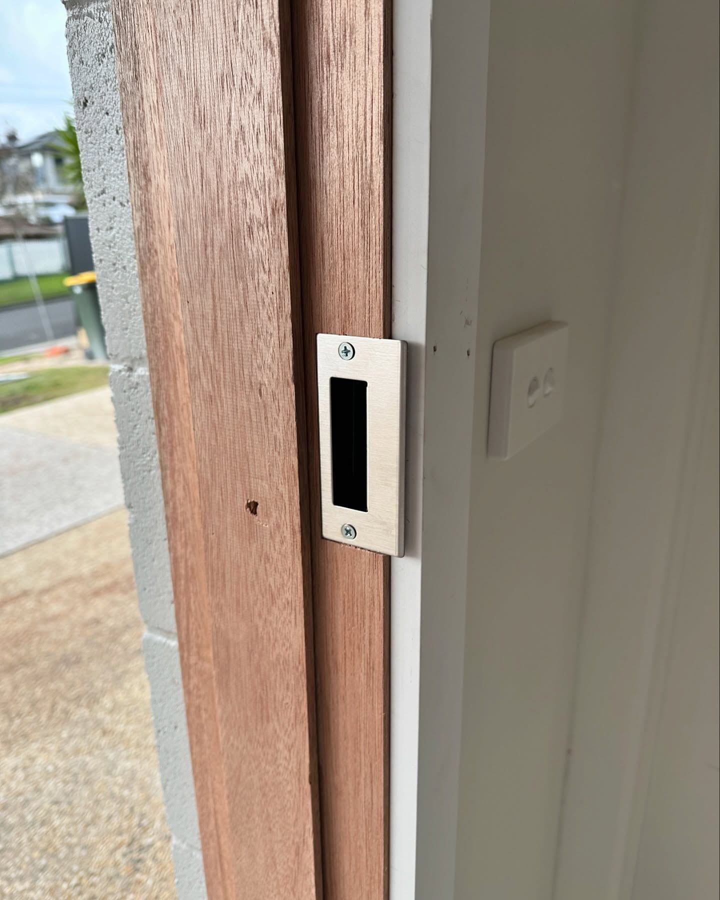 Door Frame With a Rectangular, Black Door Strike Plate Attached to a Wooden Jamb — Great Ocean Locksmiths in Belmont, VIC