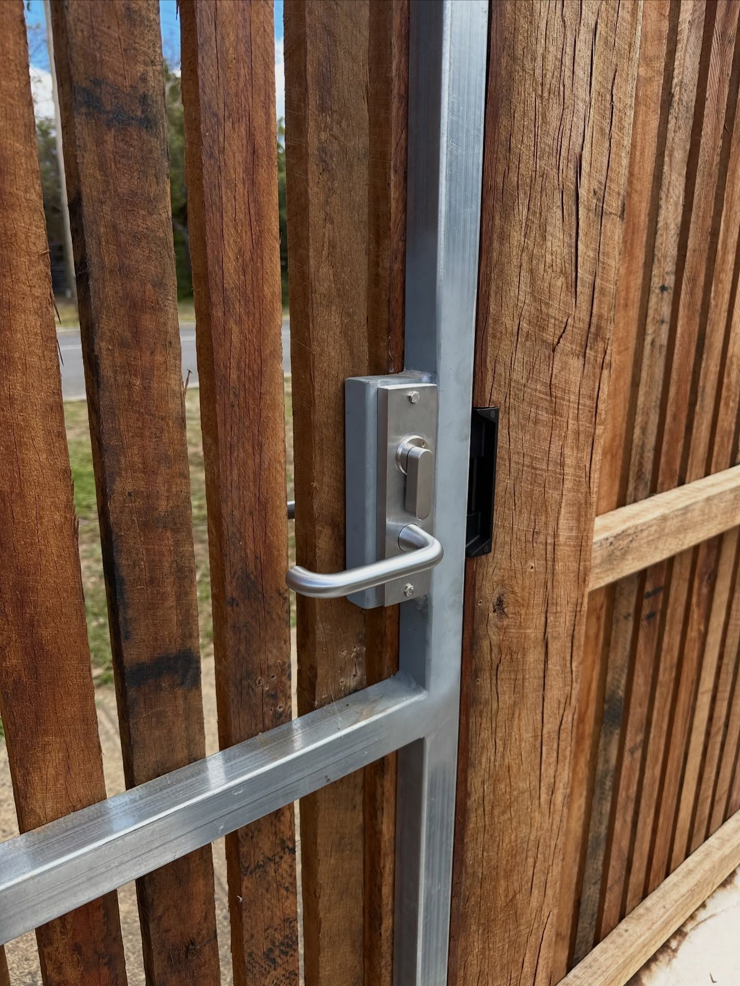 Metal gate latch on a wooden fence with vertical and horizontal boards — Great Ocean Locksmiths in Belmont, VIC