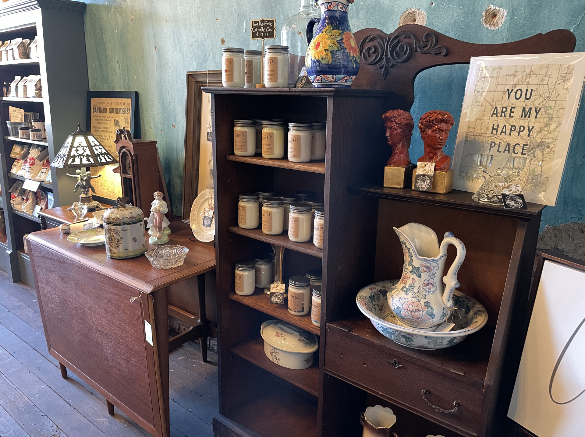 Antique shop interior with shelves, table, and assorted items for sale.