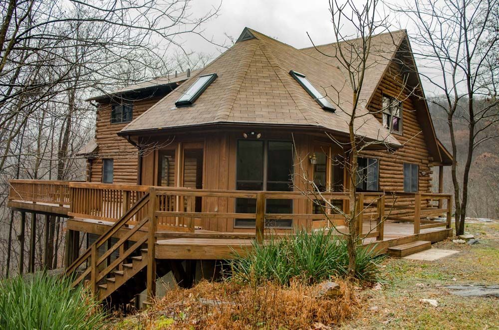 A log cabin with a large deck and stairs