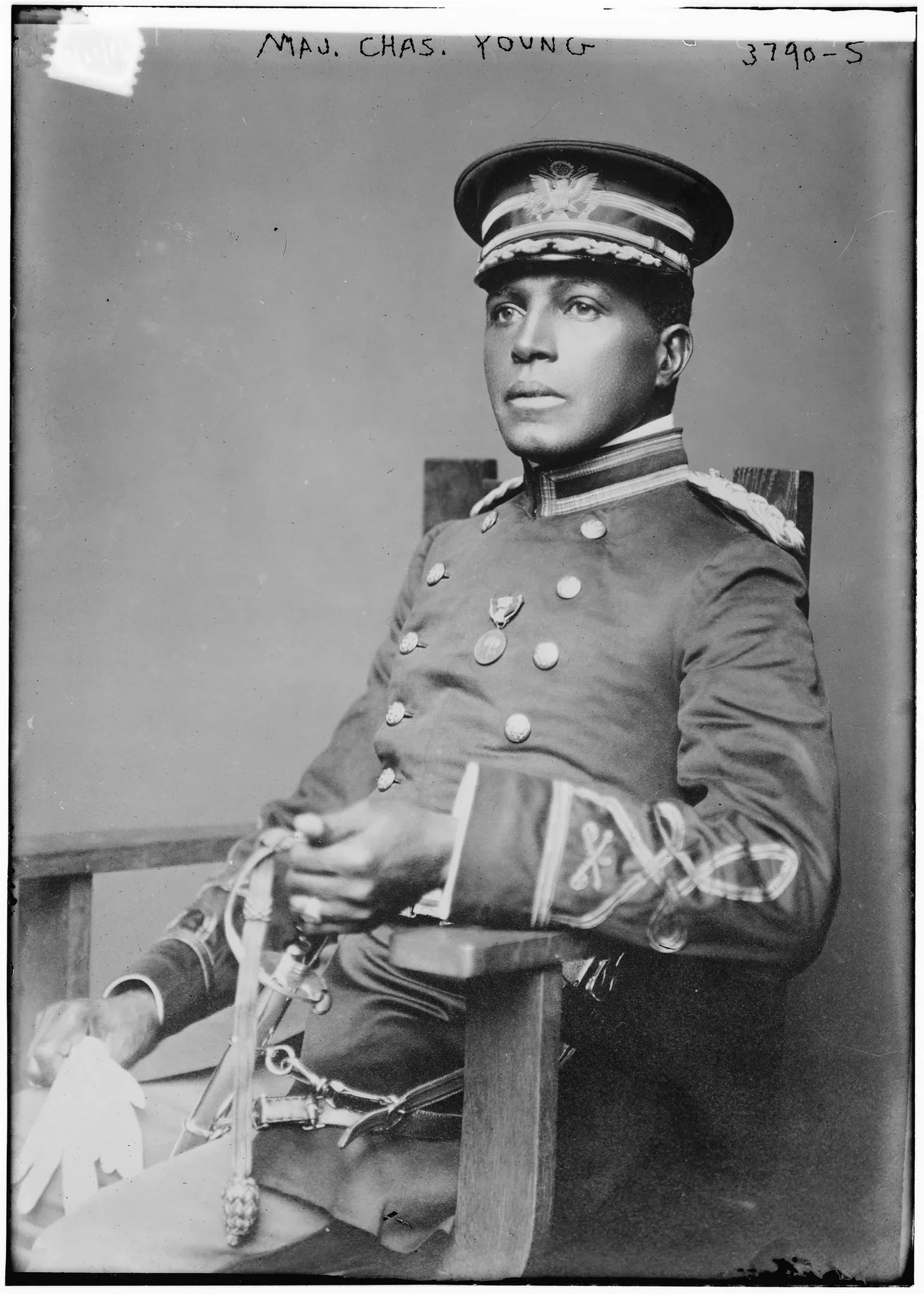 A black and white photo of a man in a military uniform sitting in a chair.