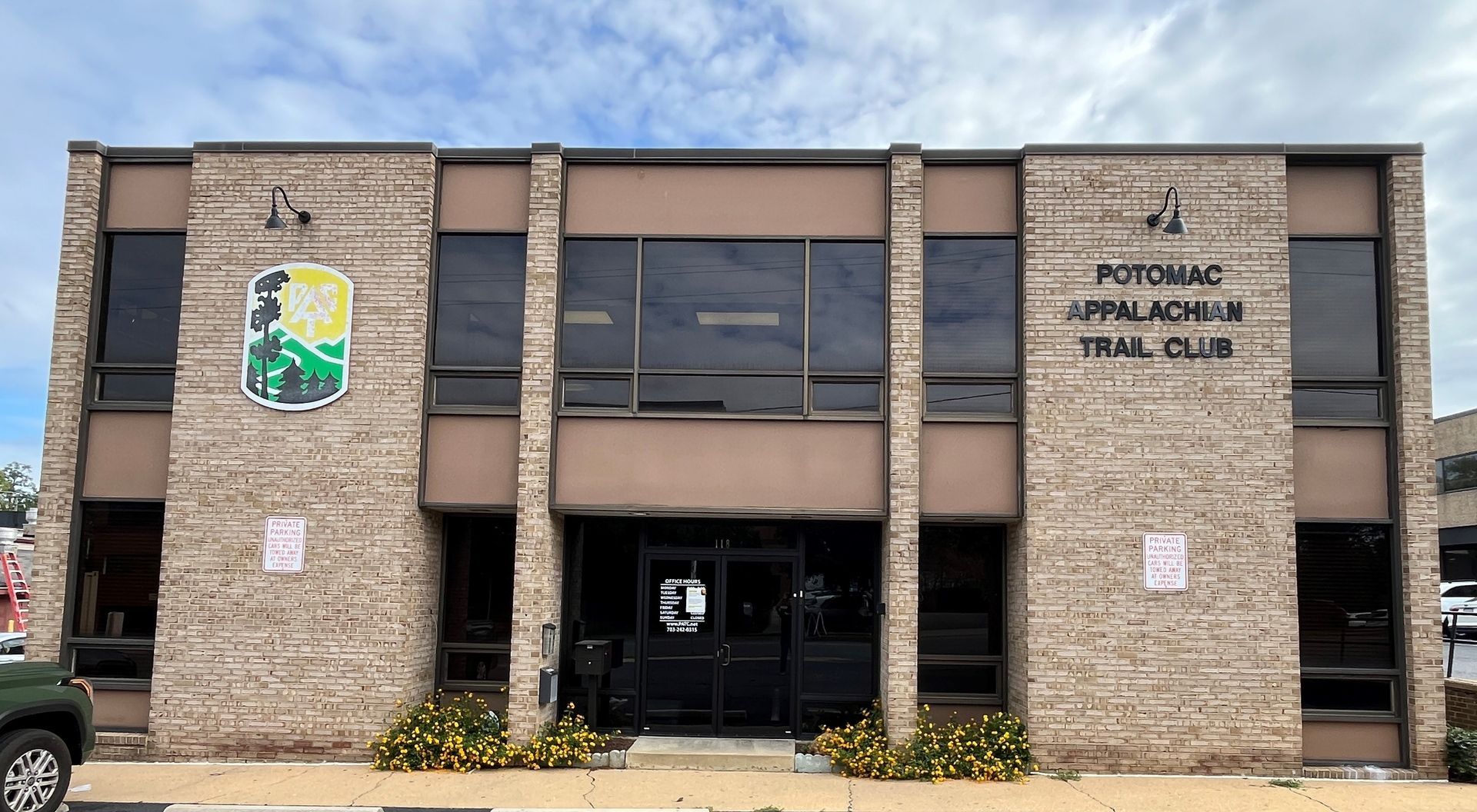 A large brick building with a trail club logo on it