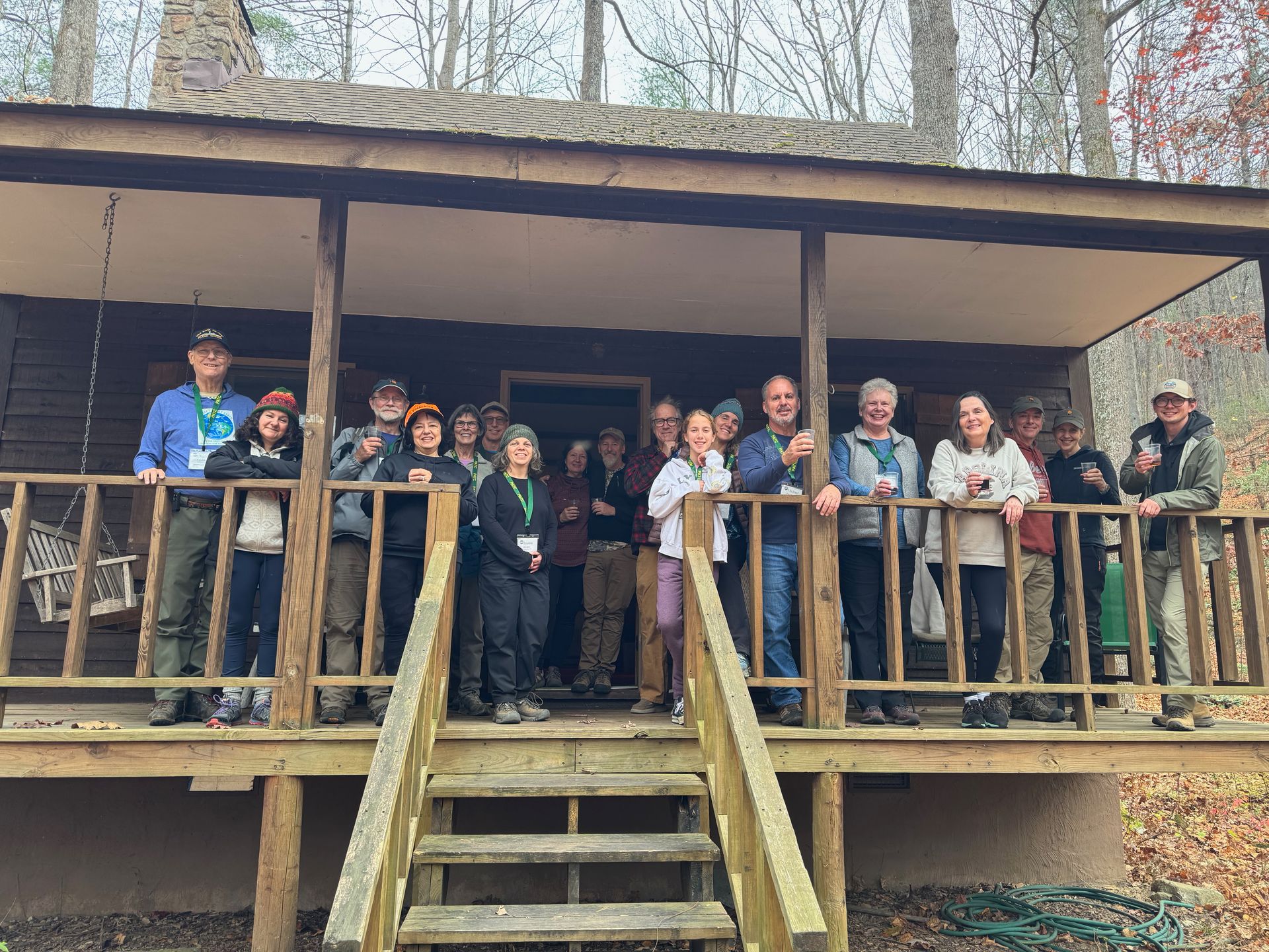 A group of people are standing on a porch of a cabin.