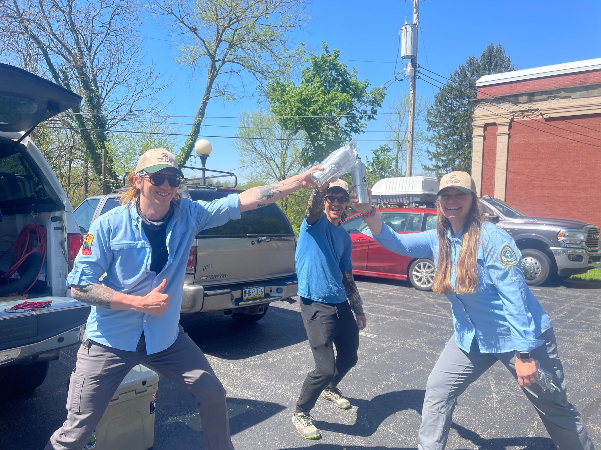 A group of people are standing next to each other in a parking lot.